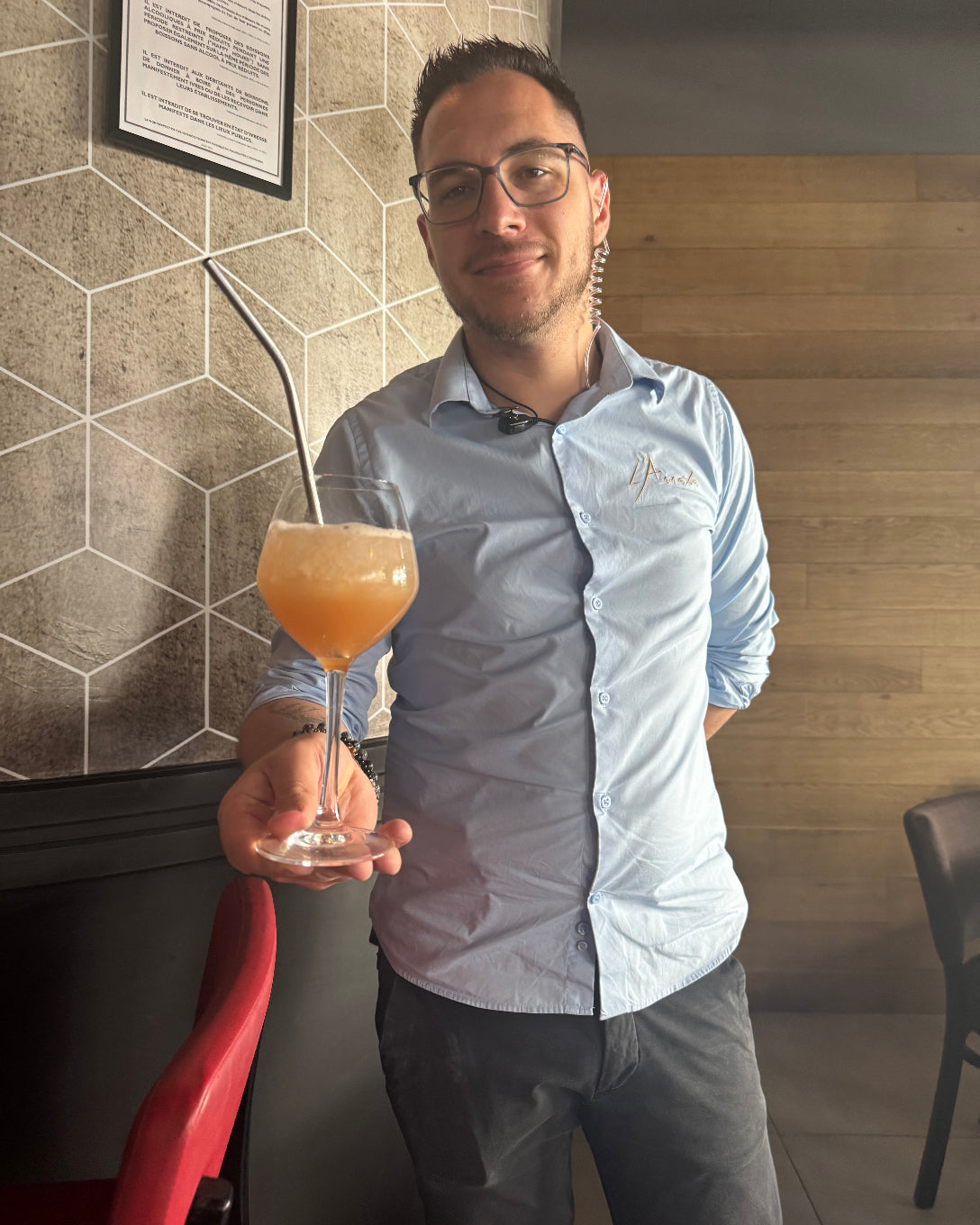 Barman de L’Annexe tenant un cocktail maison prêt à être servi dans la salle du restaurant à Chartres, juillet 2025.