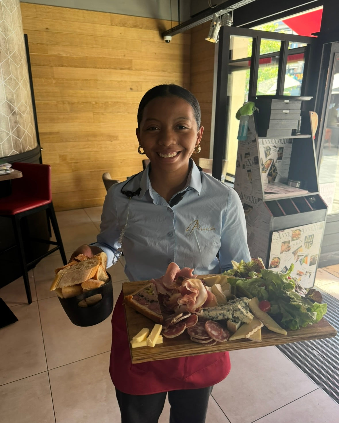 Serveuse souriante tenant une planche de charcuterie et fromage, restaurant L'Annexe Chartres