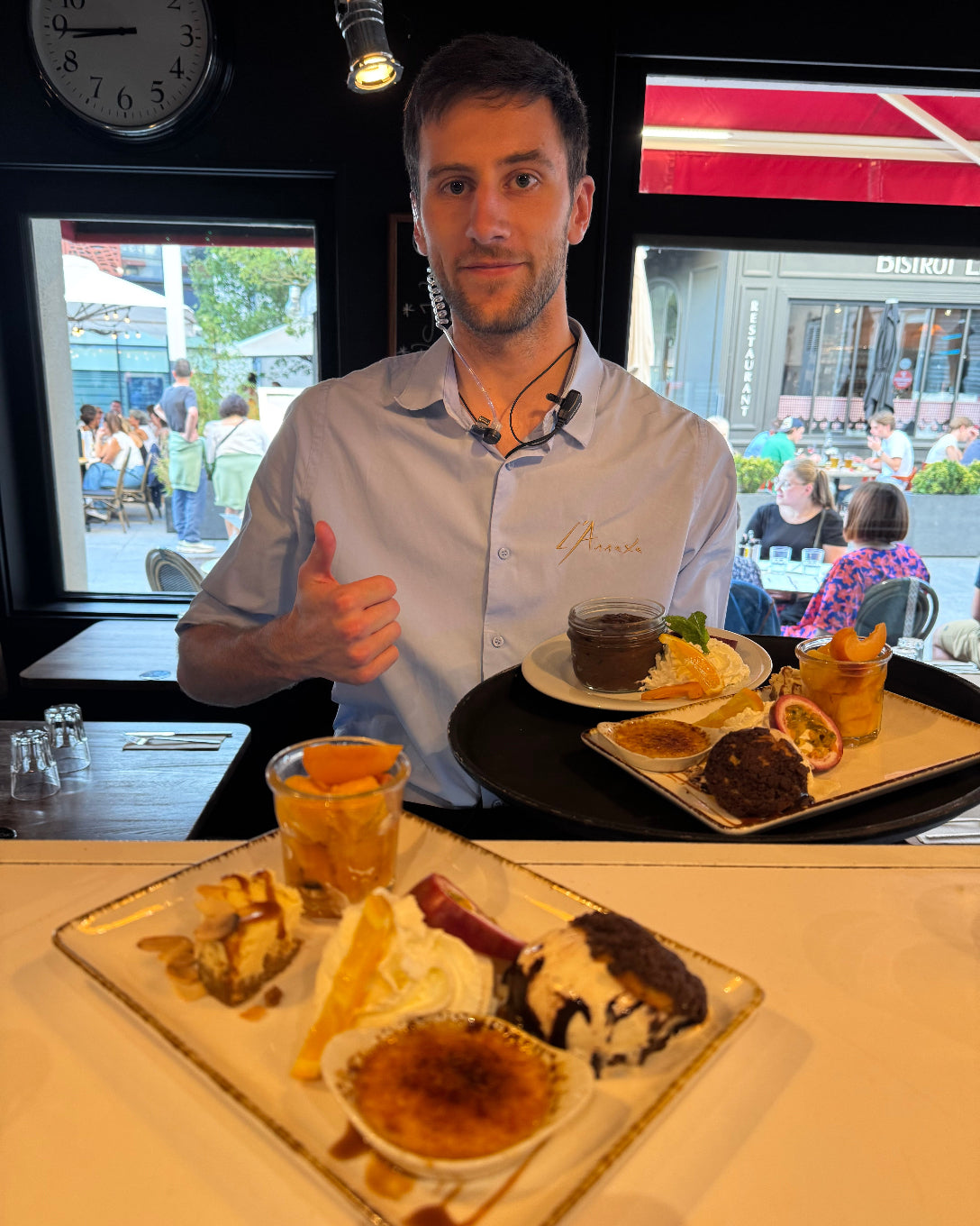 Serveur de L’Annexe présentant un plateau de desserts variés : crème brûlée, glace vanille, panna cotta, fruits frais et gâteau au chocolat — un moment sucré à partager.