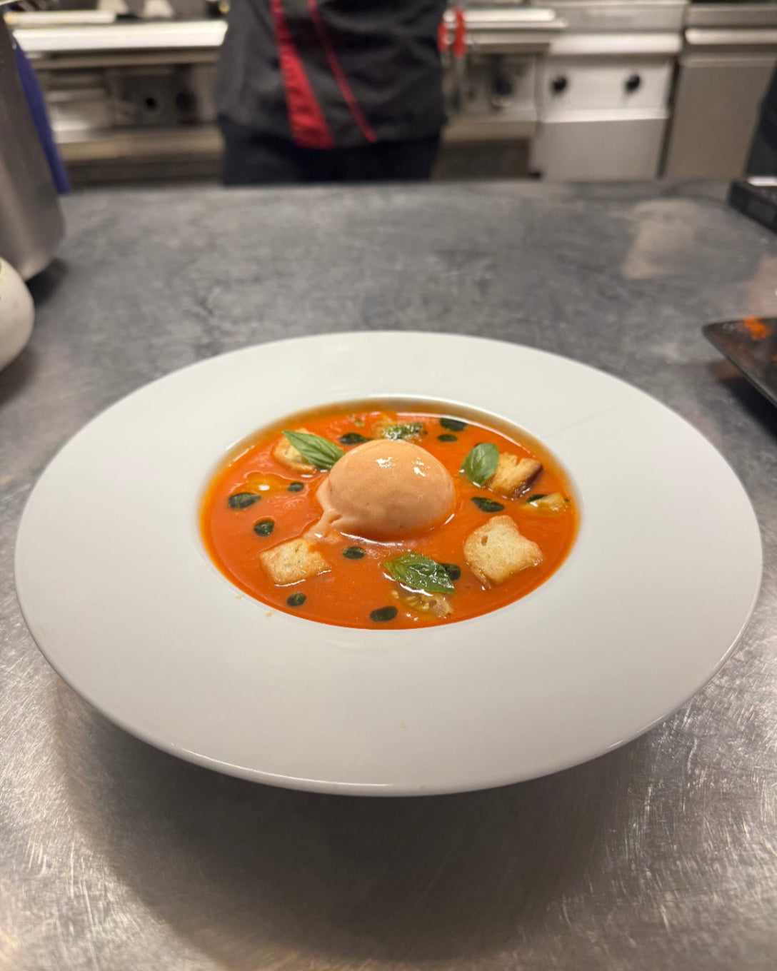 Soupe de tomates façon gaspacho servie avec croûtons dorés, feuilles de basilic et quenelle glacée au restaurant L’Annexe à Chartres