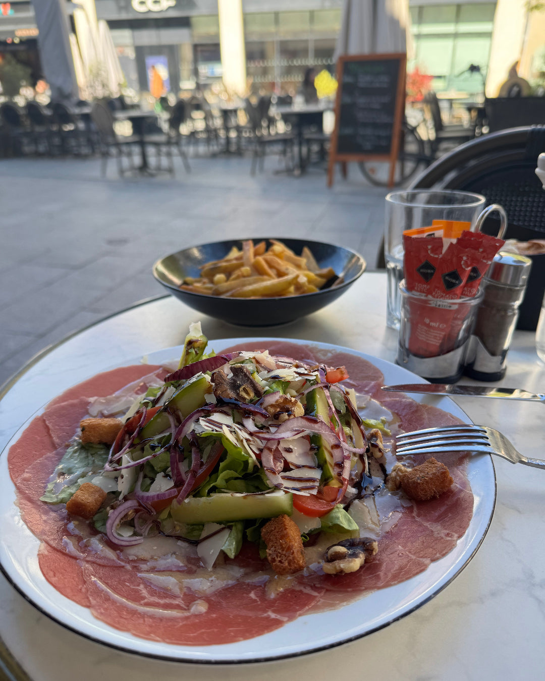 Salade avec prosciutto, légumes frais et frites sur une terrasse de restaurant à Chartres